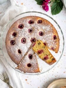 overhead of raspberry ricotta cake with two cut slices