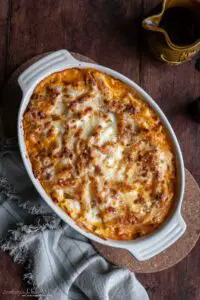 oval baking dish with baked pasta on a grey towel