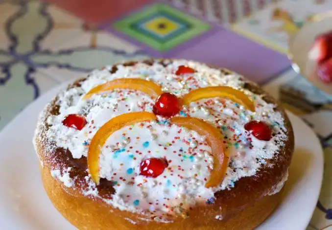 sweet casatiello cake on a plate, topped with candied fruit and sprinkles