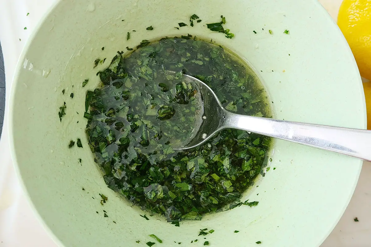 bowl with lemon herb dressing and a spoon