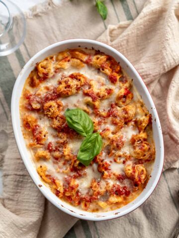 oval baking dish with tomato cheese baked tortellini