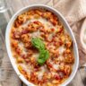 oval baking dish with tomato cheese baked tortellini