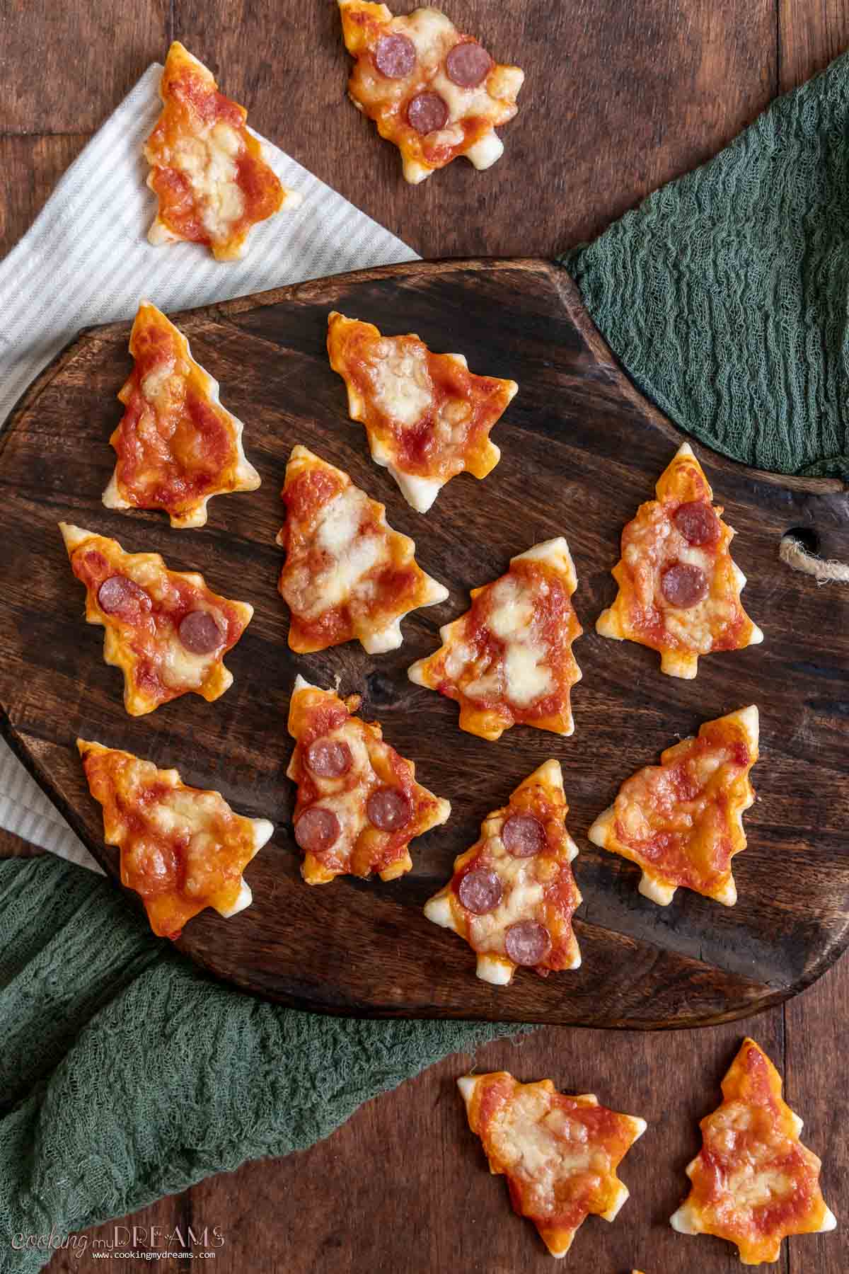 christmas tree mini pizzas on a cutting board.