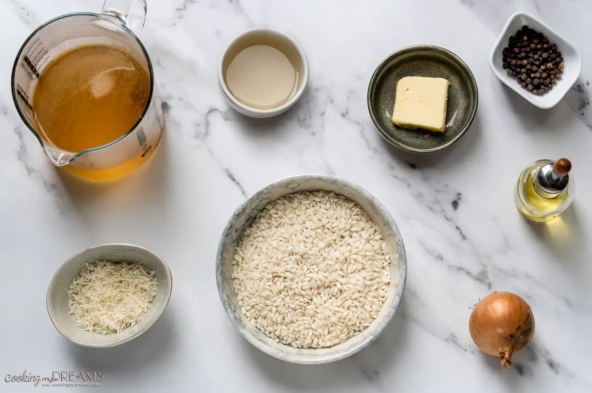 ingredients to make risotto on a marble table.