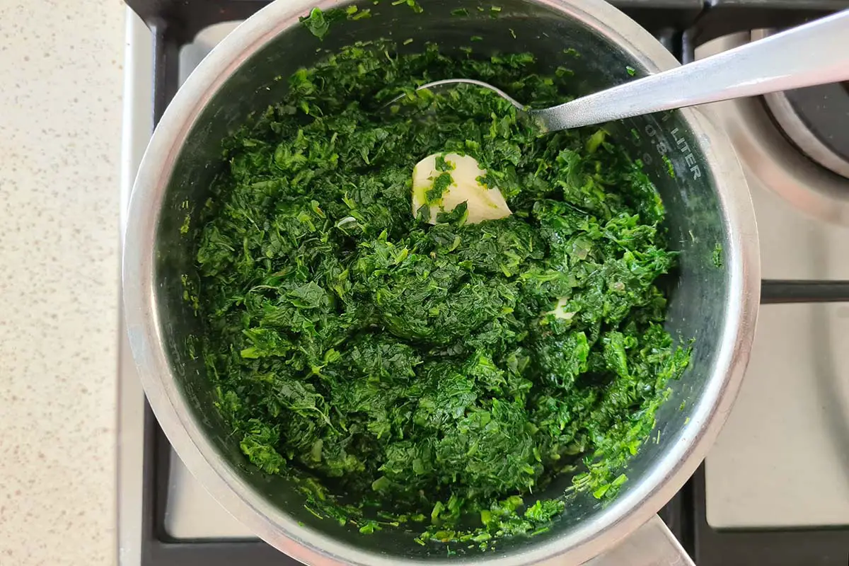 spinach cooking in a pot with garlic.
