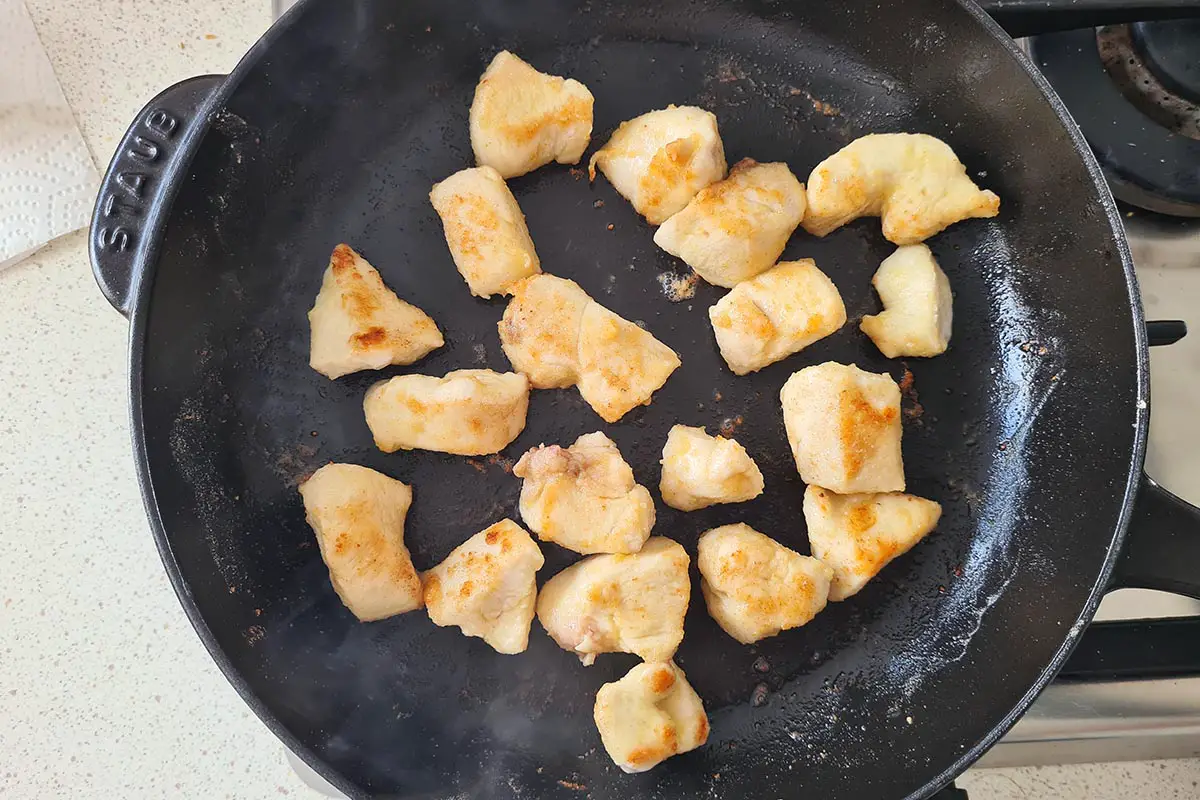 chicken breast bites browning in a skillet.
