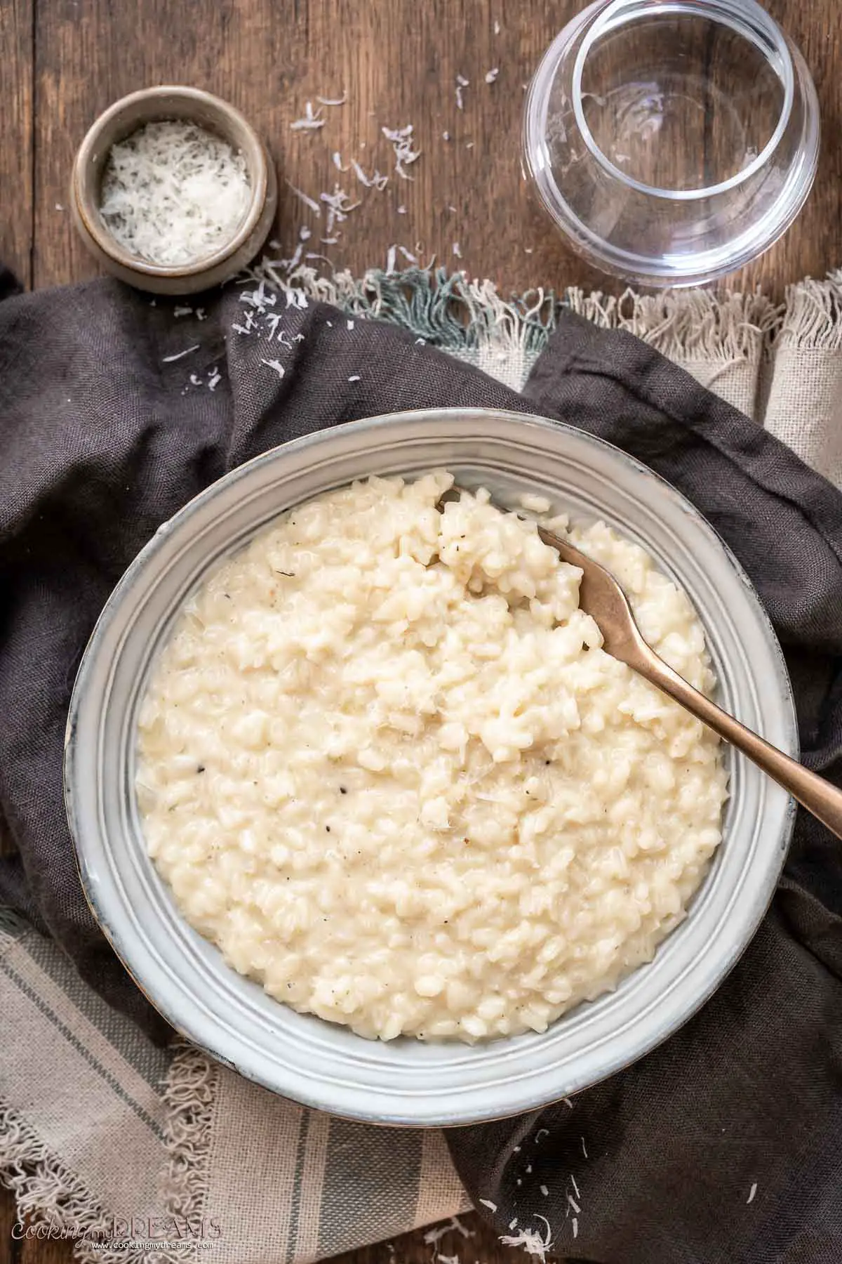 creamy garlic parmesan risotto on a plate with a fork.
