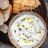 whipped ricotta dip in a bowl next to bread and crackers