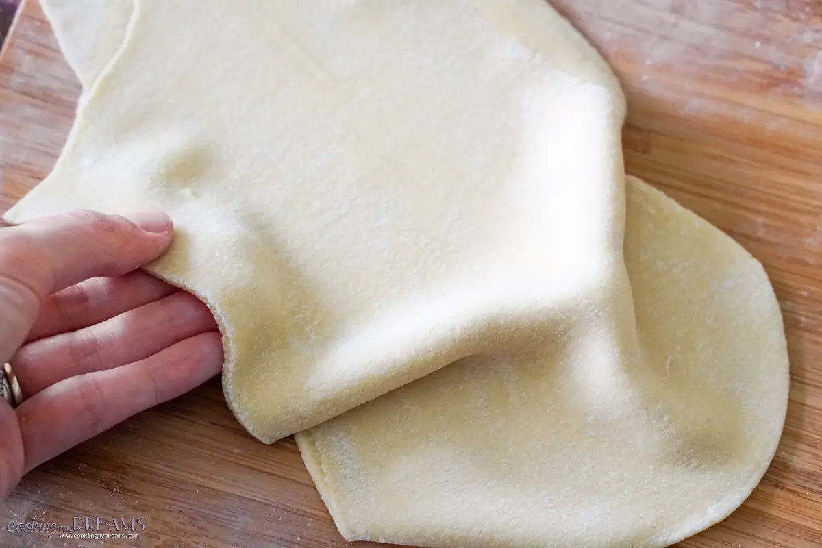 hand holding a sheet of pasta dough