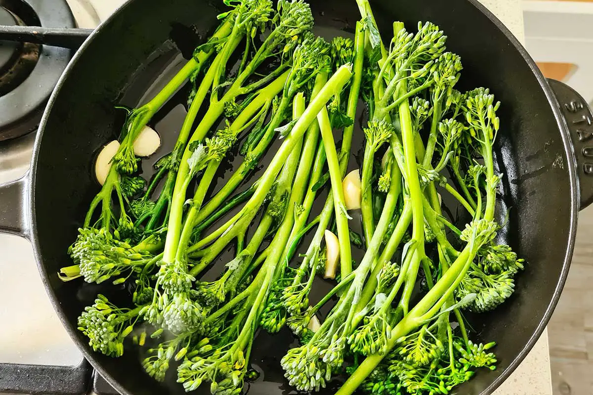 broccolini cooking in a skillet.