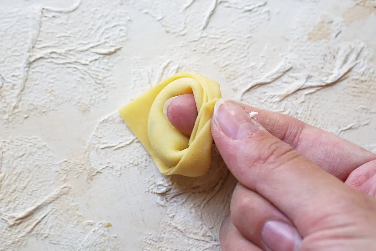 the edges are folded around the finger to make the tortelloni shape.