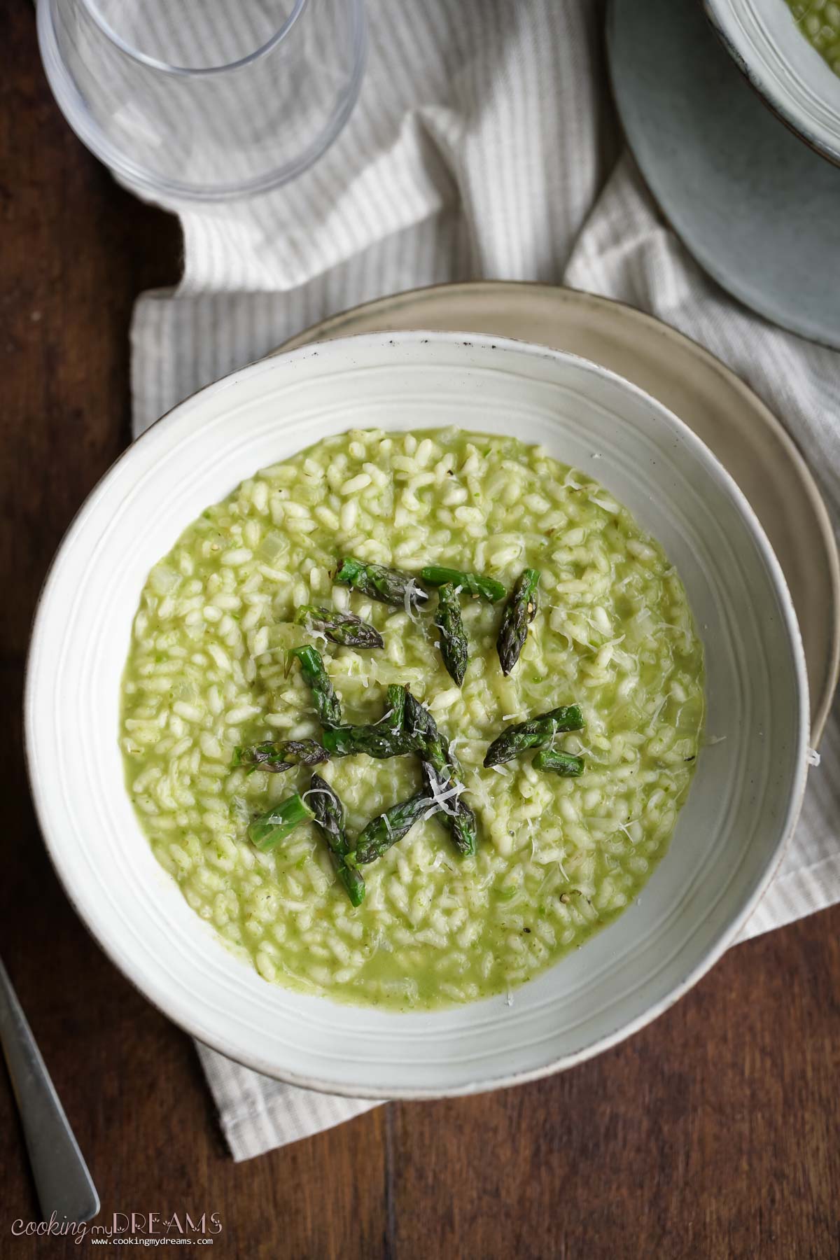 a bowl of asparagus risotto topped with asparagus.