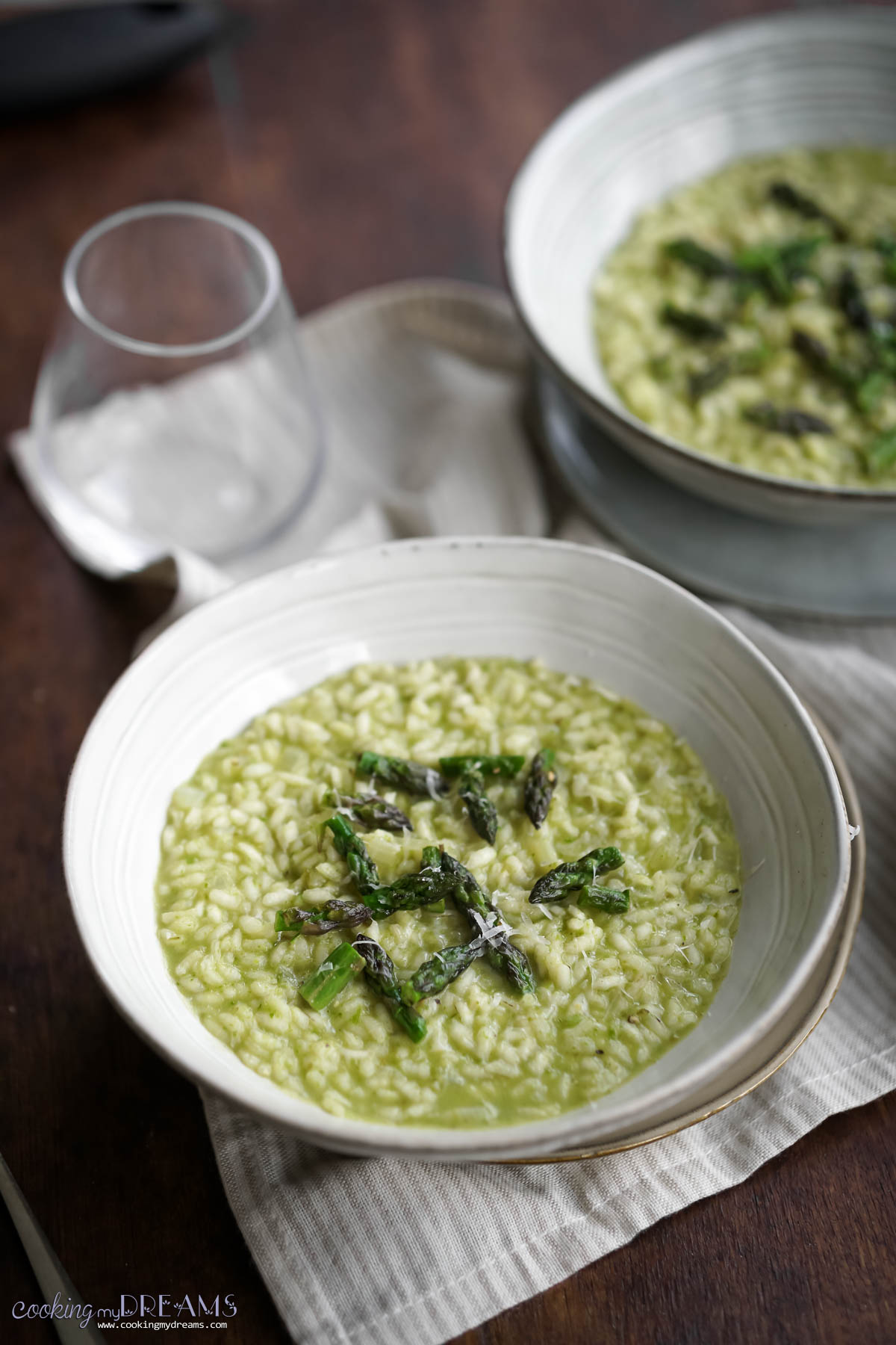 two bowls of asparagus risotto on a table.