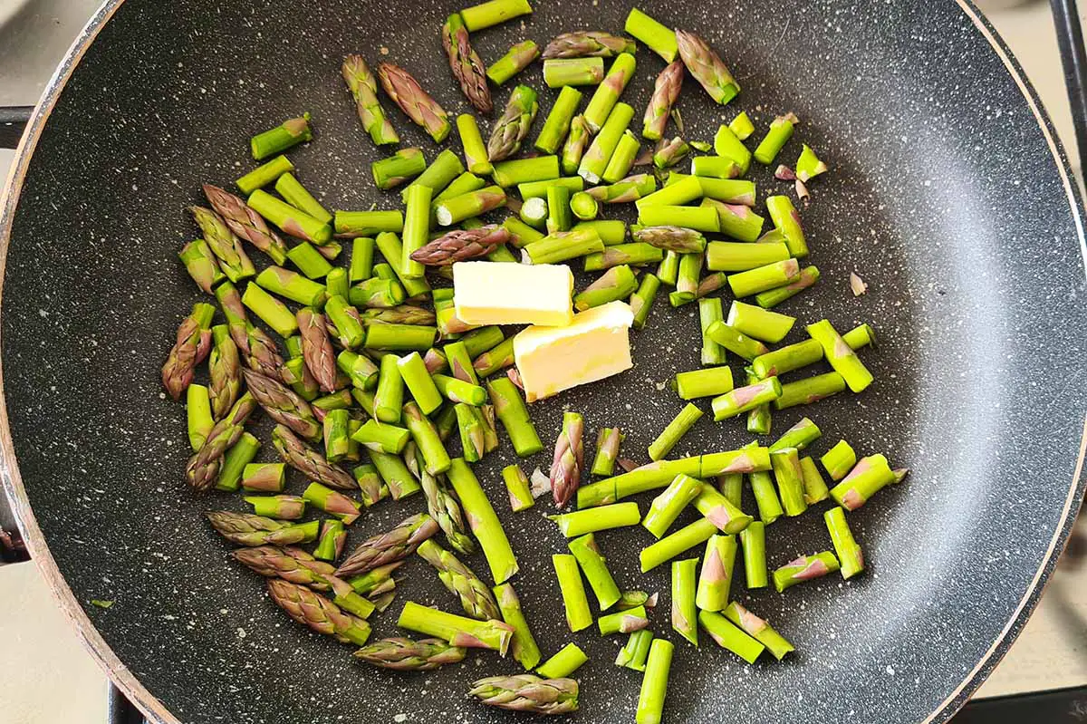 asparagus tips in a pan with butter.