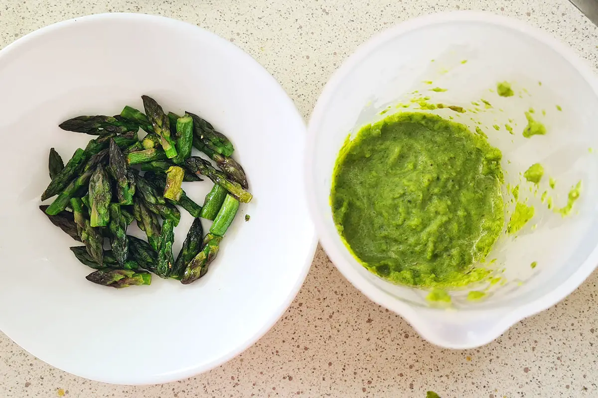 one bowl with cooked asparagus tips and the other with blended asparagus sauce.