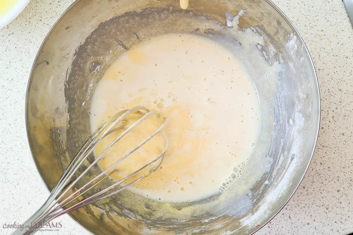 whisk mixing egg mixture with a bit of hot milk.