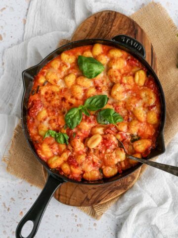 gnocchi alla sorrentina in a cast iron skillet with a spoon.
