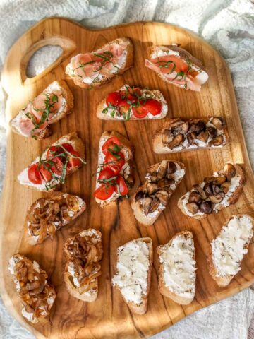 goat cheese crostini on a wooden board.