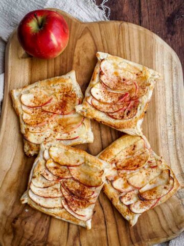 puff pastry apple tarts on a wooden board.