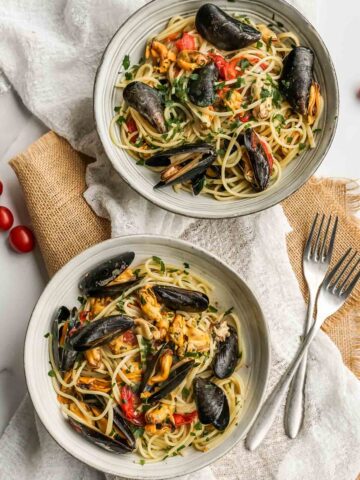 two bowls of linguine with mussels.