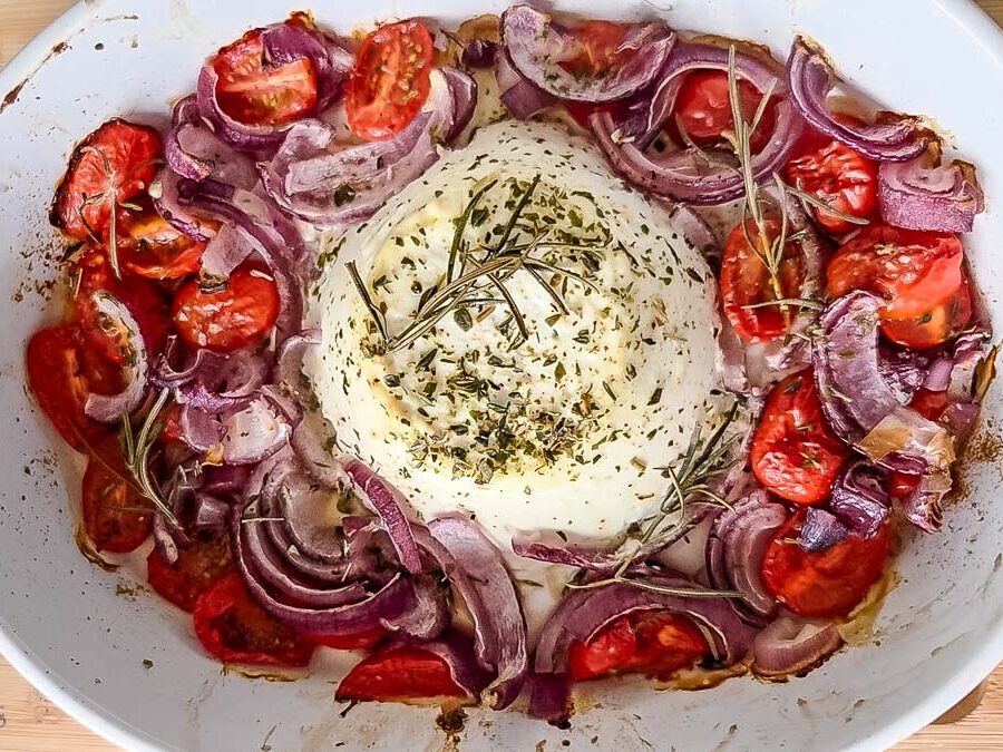 baked ricotta with onions and tomatoes in a baking dish.