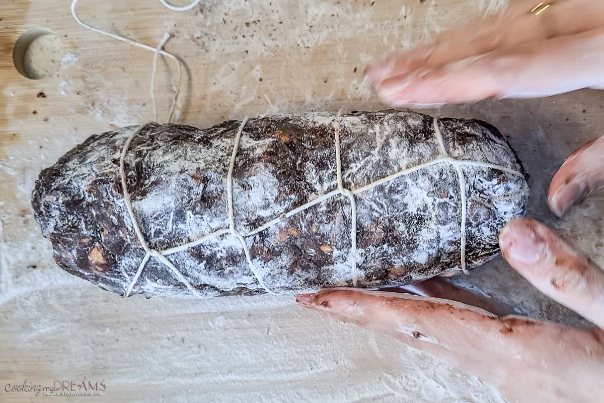 hands wrapping the chocolate salami with twine.