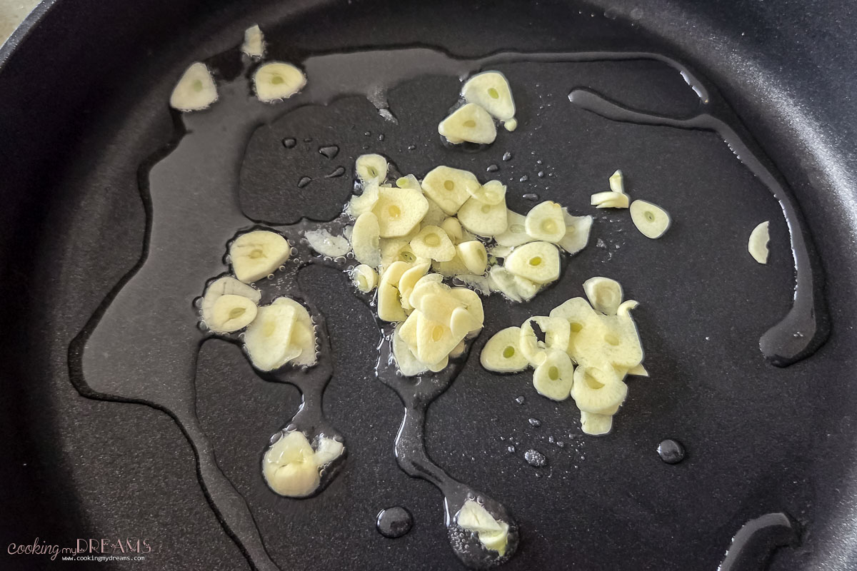 garlic and oil cooking in a skillet.