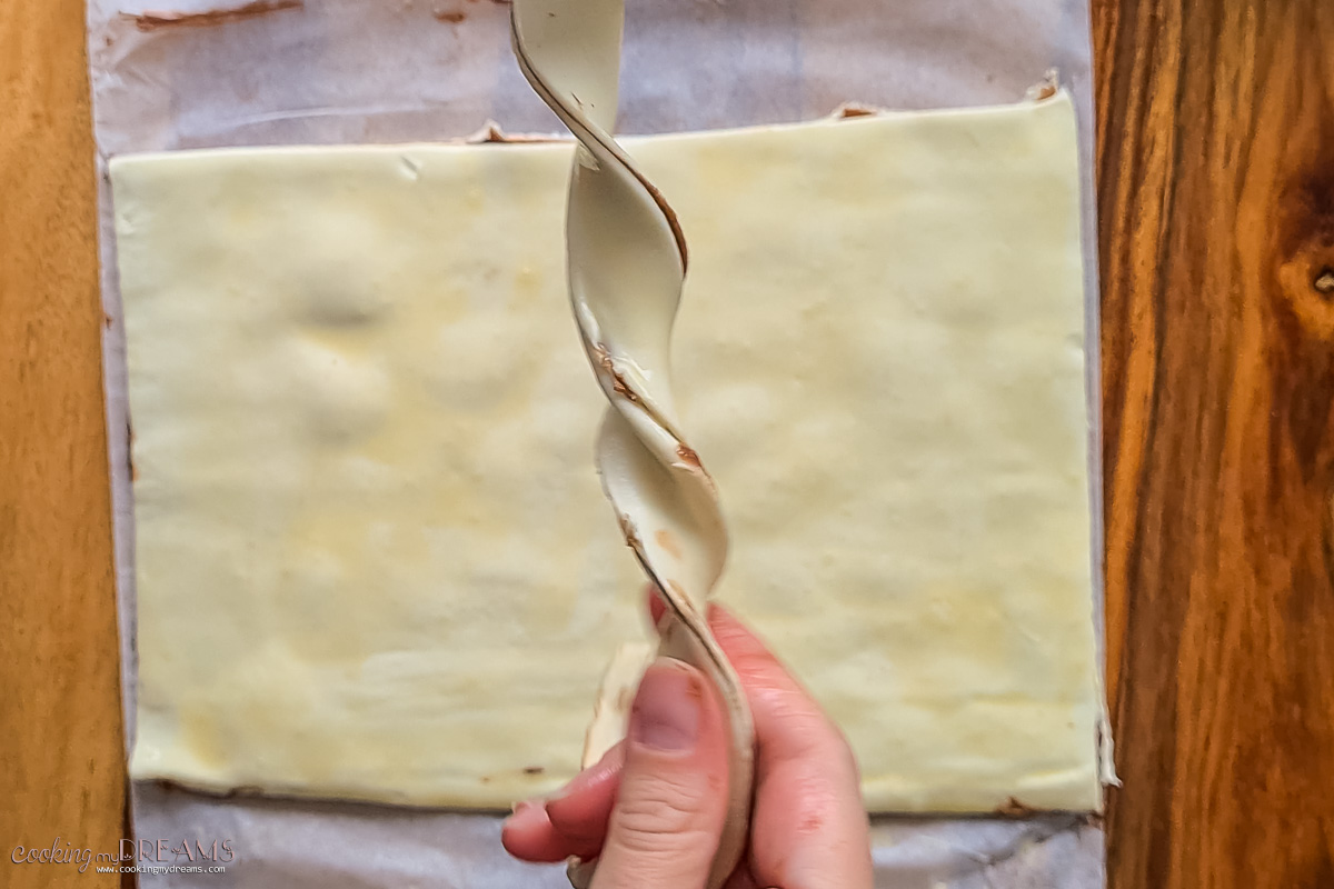 hands twisting the puff pastry stripes.