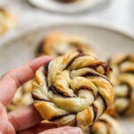 hand holding a nutella puff pastry swirl.