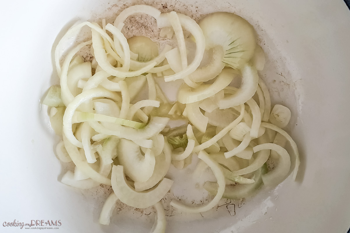 onions and garlic cooking in a dutch oven.