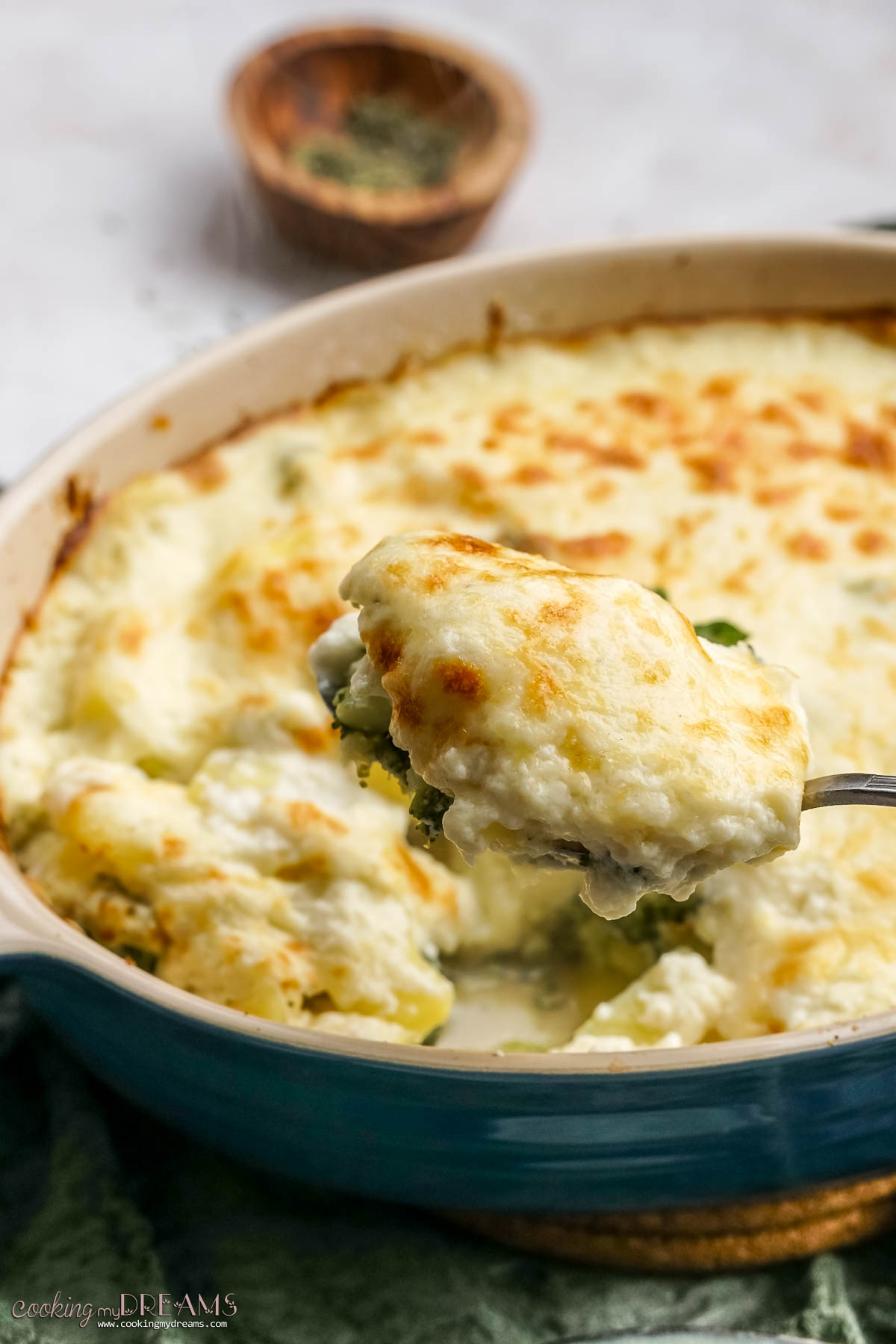 spoon taking a portion of potato broccoli bake.