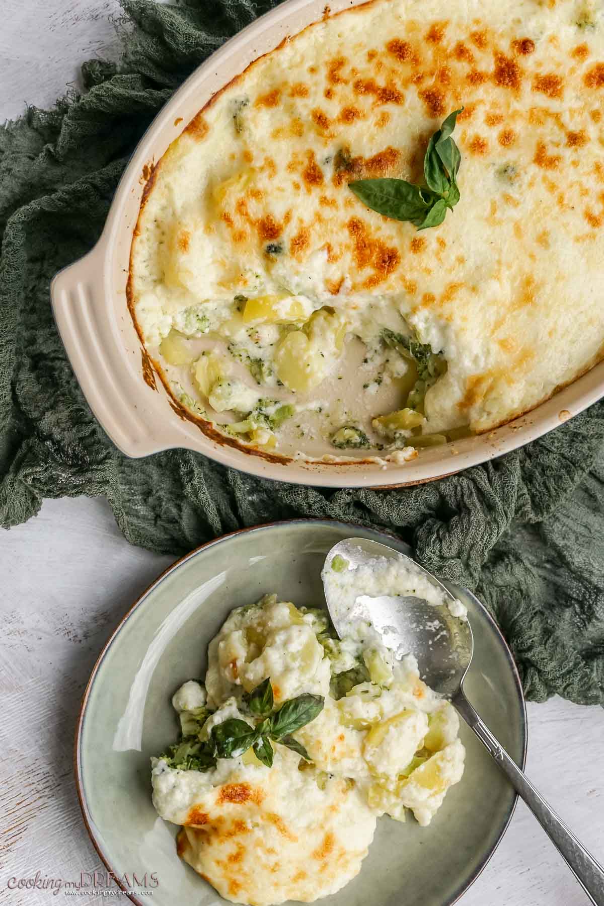 potato broccoli casserole in the baking dish and a portion on a plate.