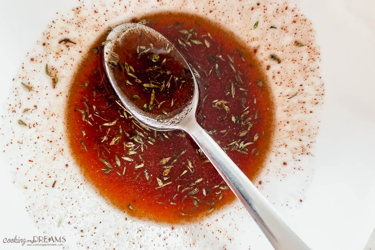 spoon mixing marinade in a bowl.