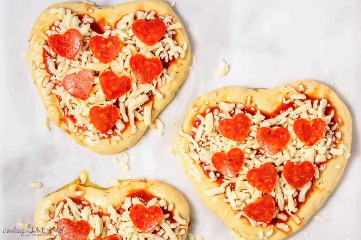 heart pizza with toppings ready for the oven.