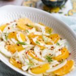 italian orange fennel salad on a serving dish topped with pine nuts.