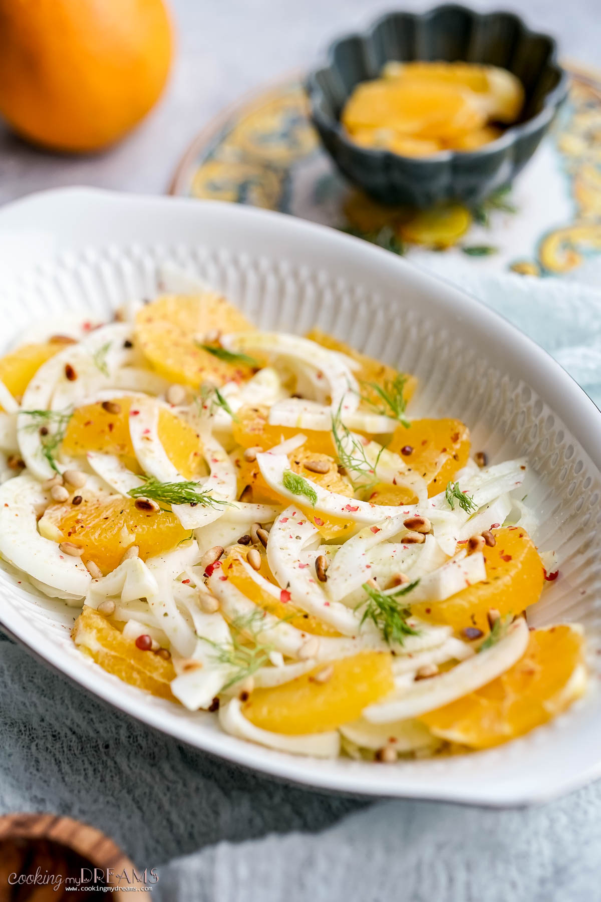 italian orange fennel salad on a serving dish topped with pine nuts.