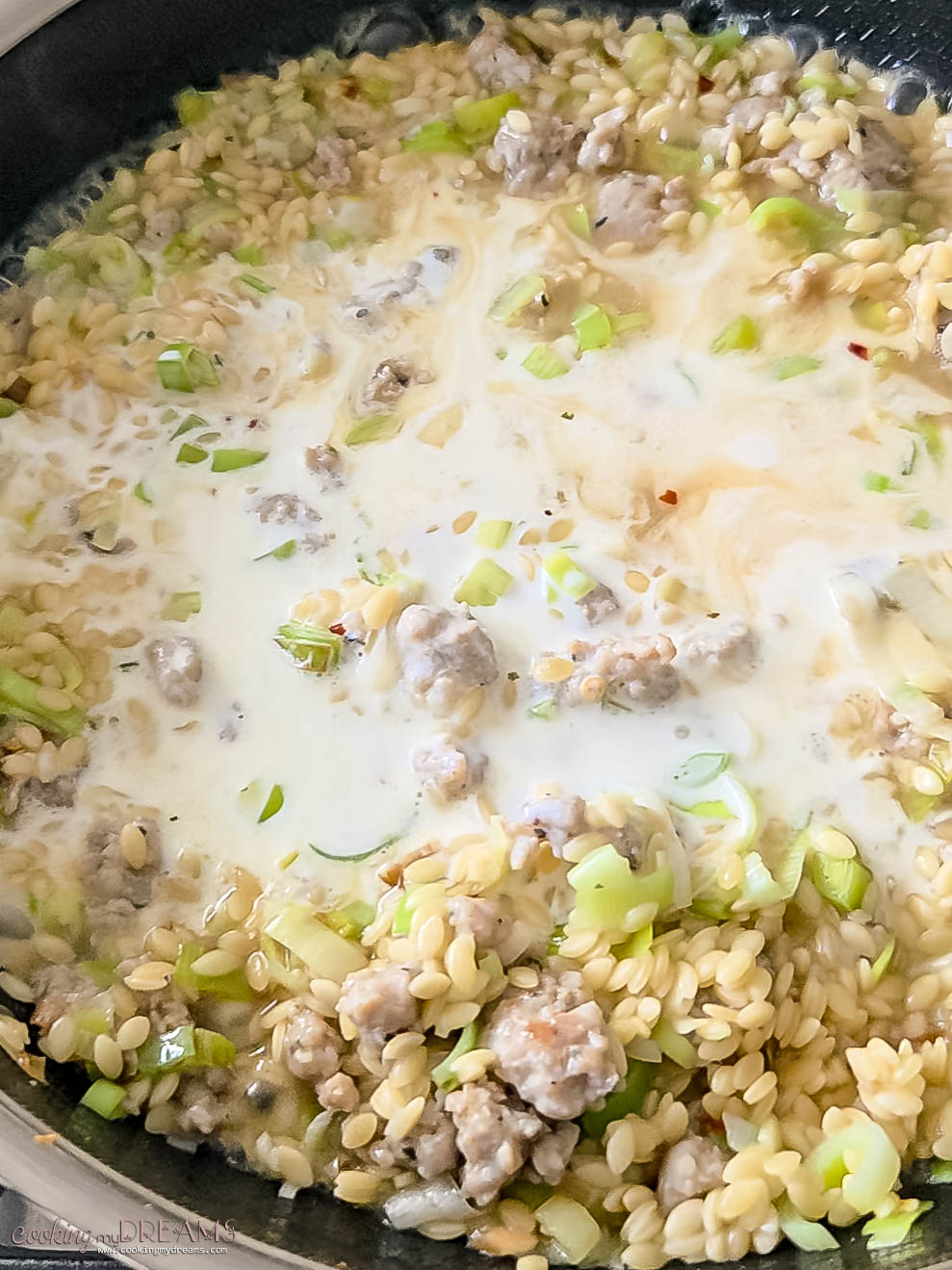 cream is added to the skillet with the orzo.