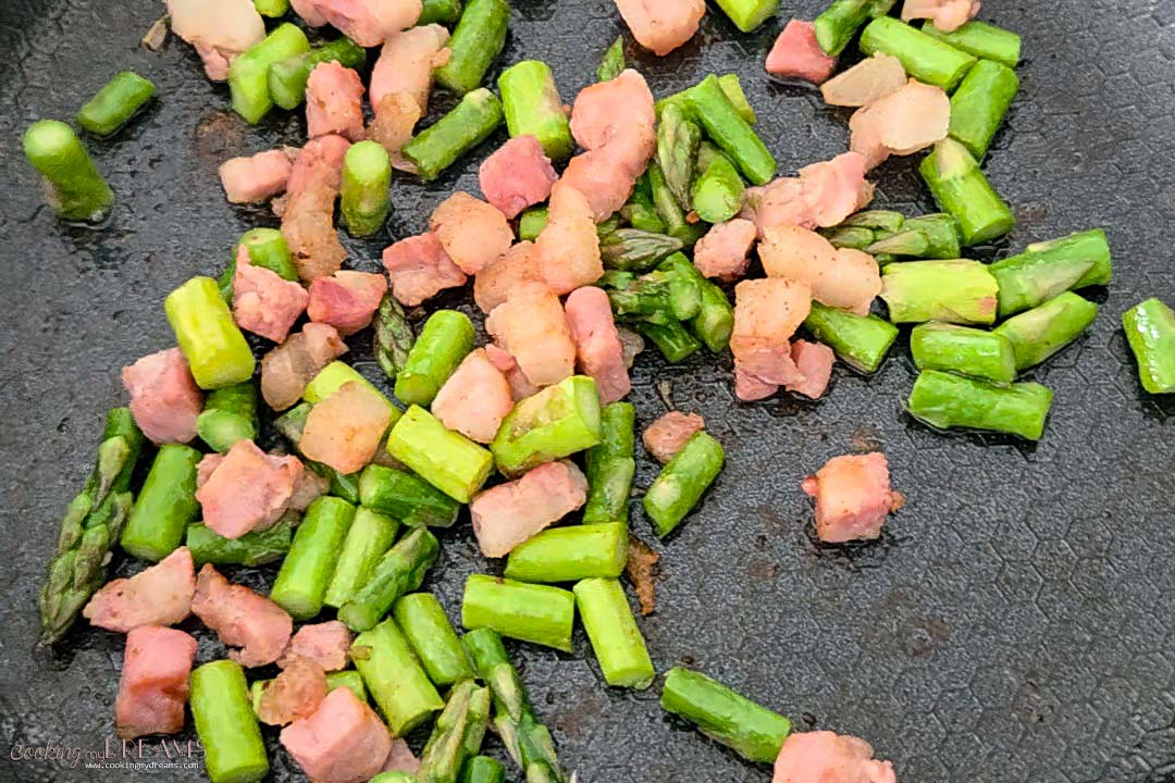asparagus and pancetta cooking in a pan.