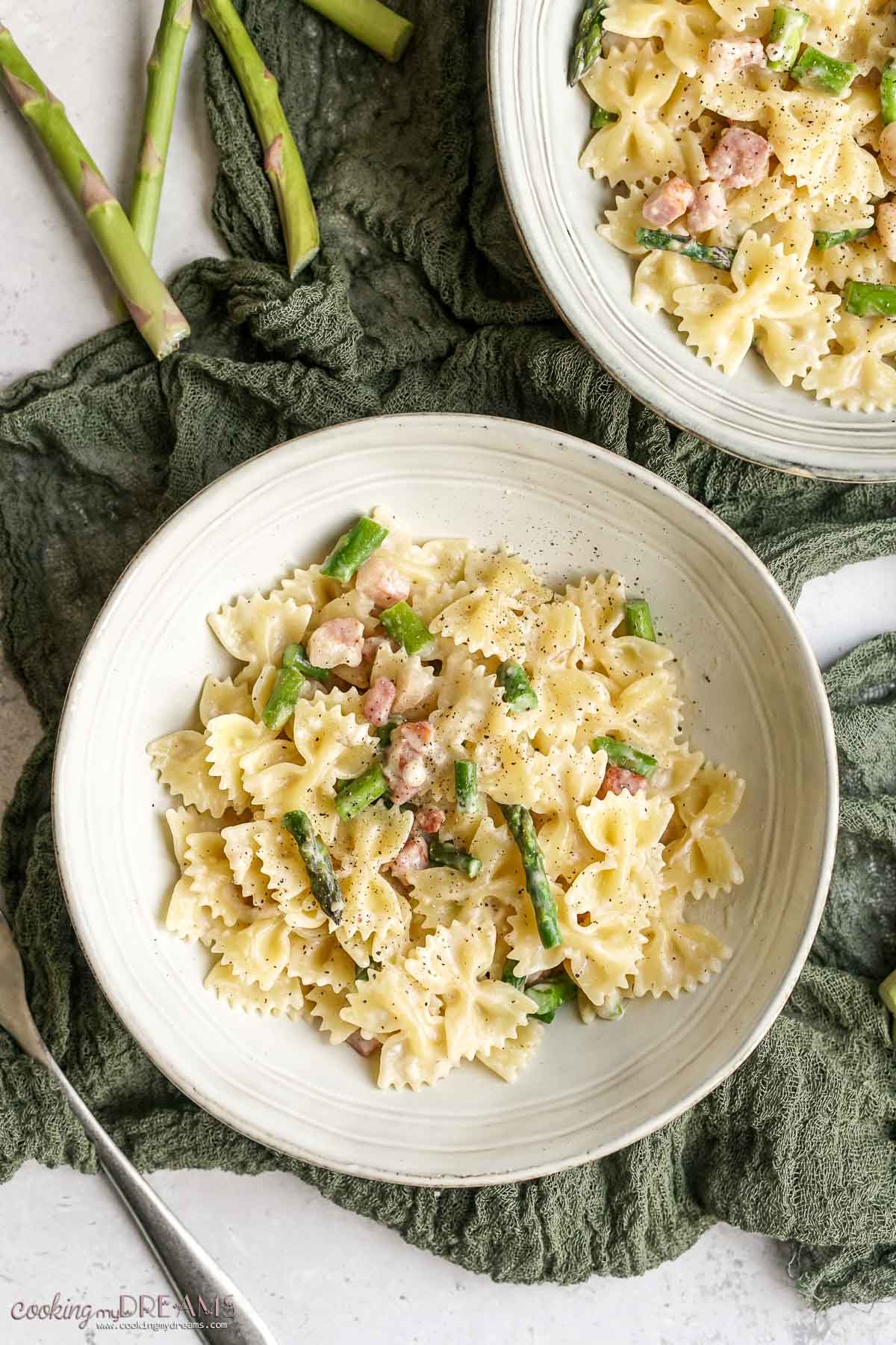 two bowls of creamy pasta with aspragus and pancetta.