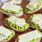 fava beans and pecorino cheese crostini on a wooden board.