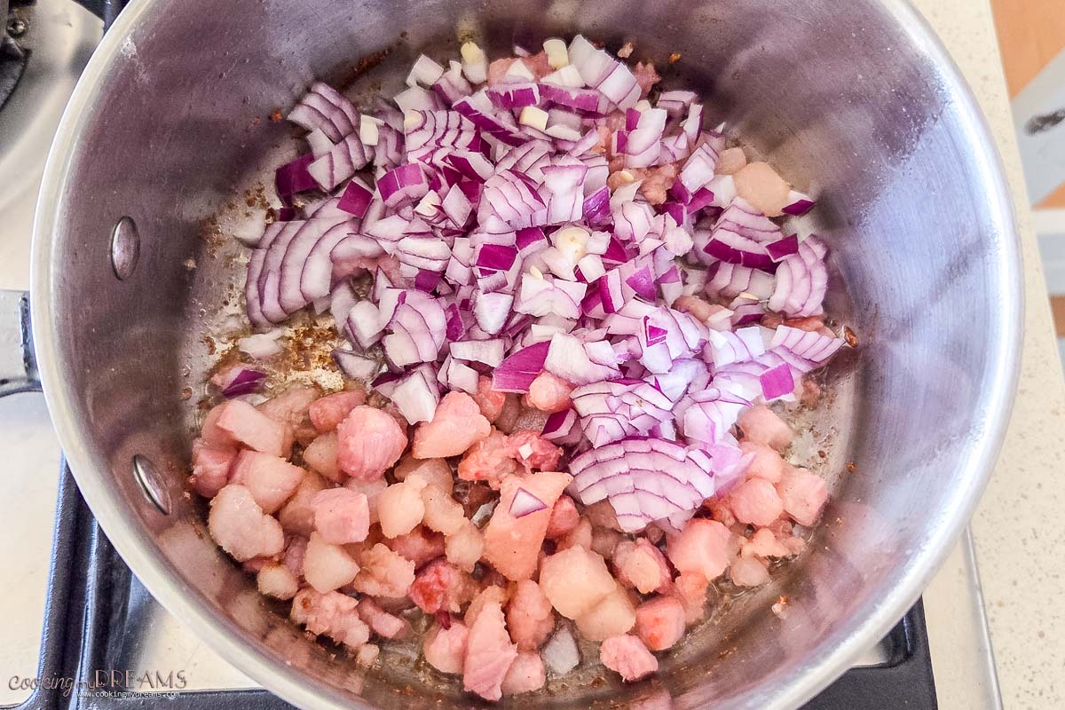 onion and guanciale cooking in a pot.