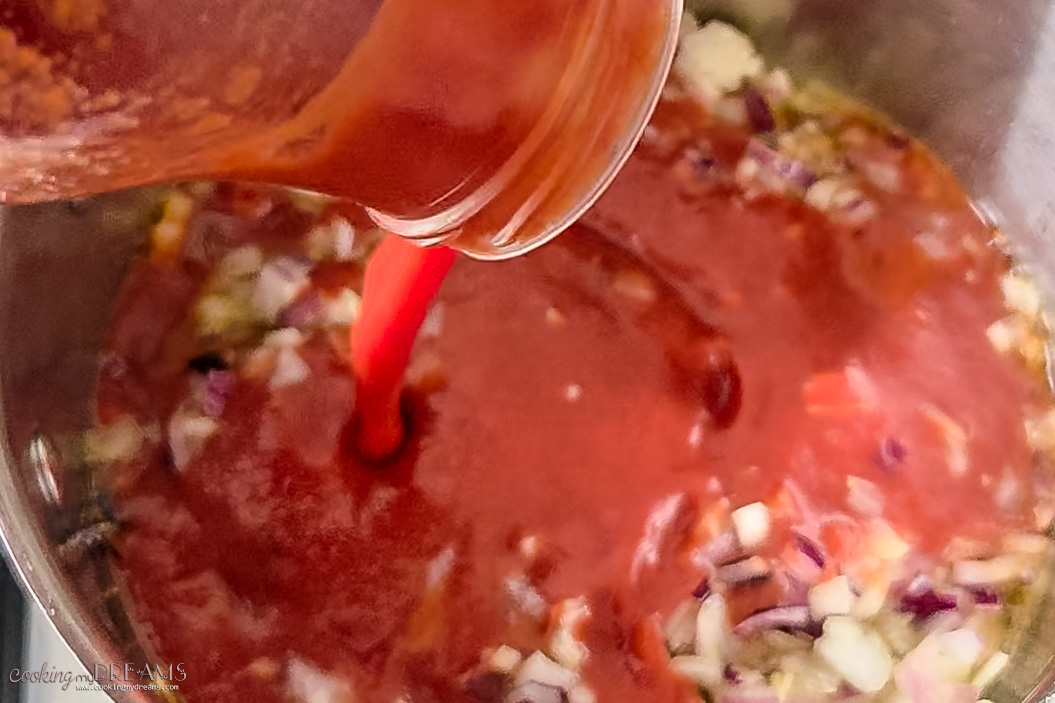 tomato passata pouring in the pan.