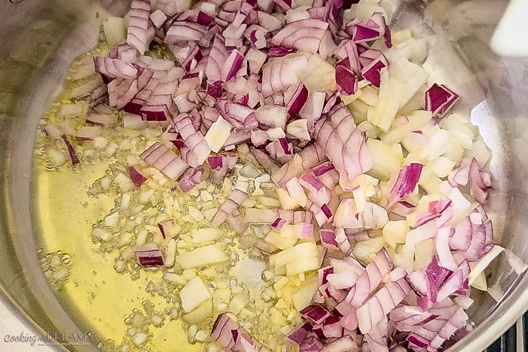 onions and garlic sauteeing in oil in a pan.