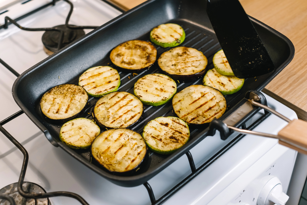 eggplant slices grilling on a grill pan.