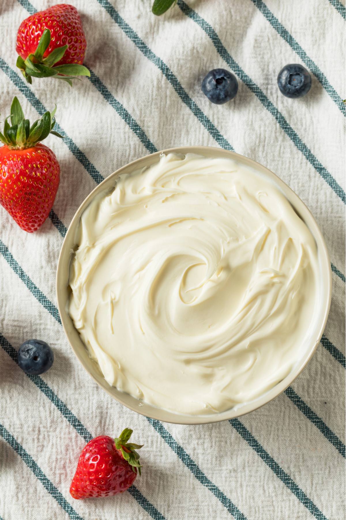 mascarpone cream in a bowl surrounded by berries.