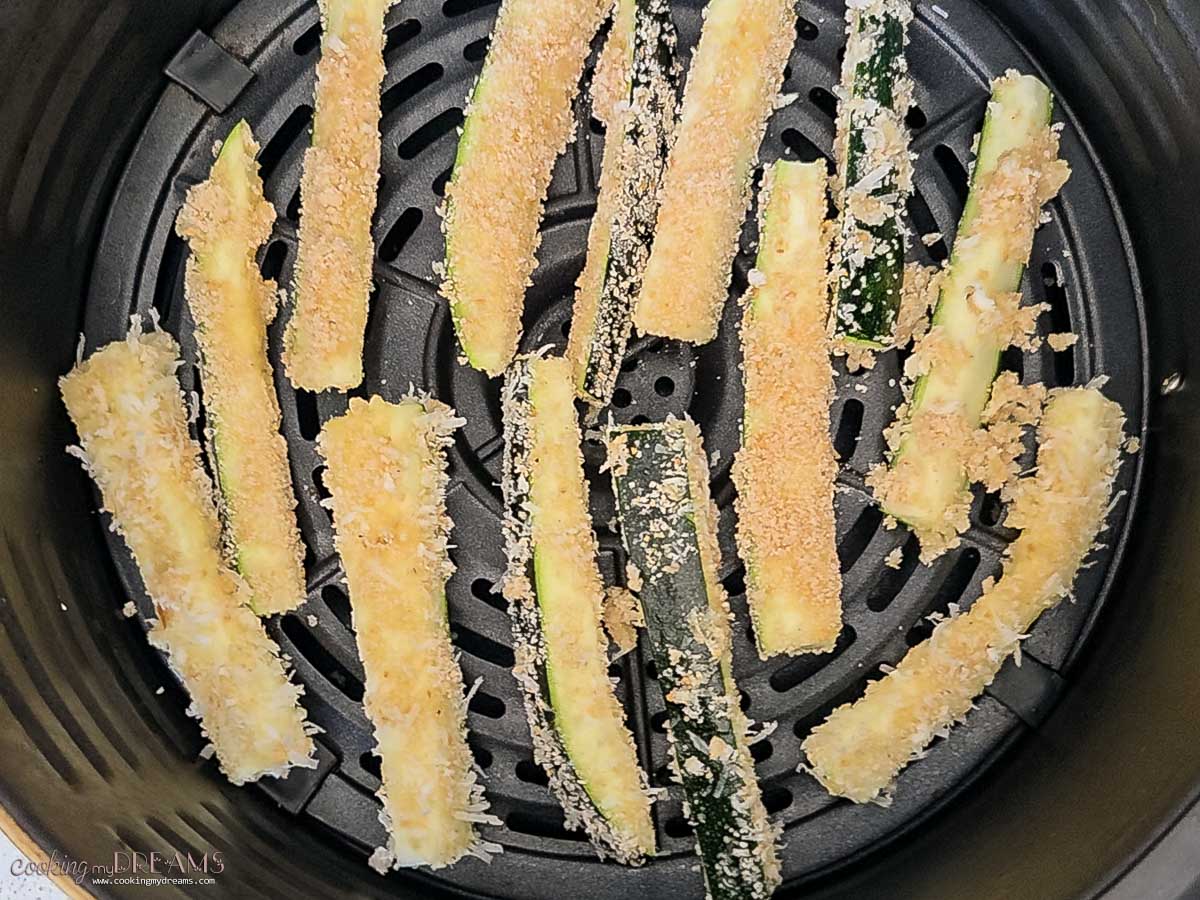 zucchini fries in the air fryer ready to bake.