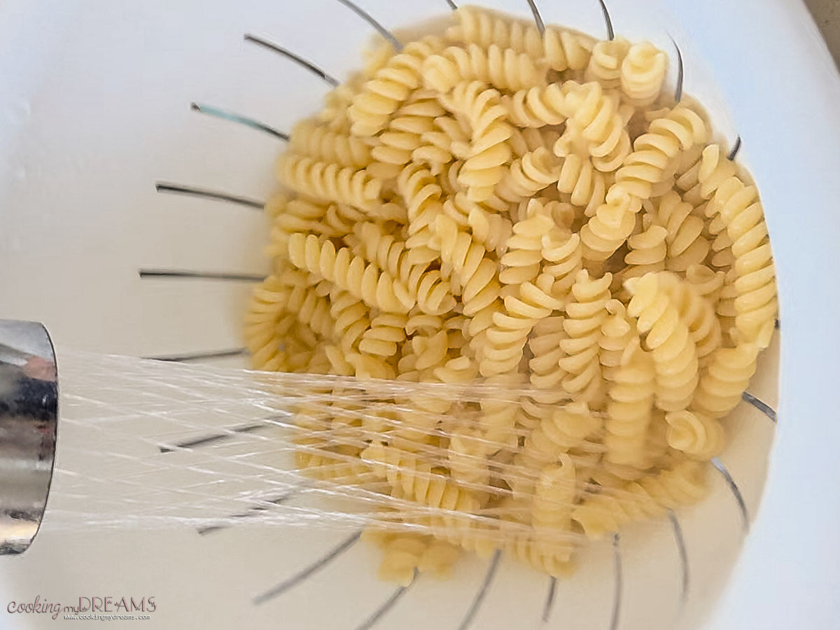 pasta washed in a colander to stop cooking.