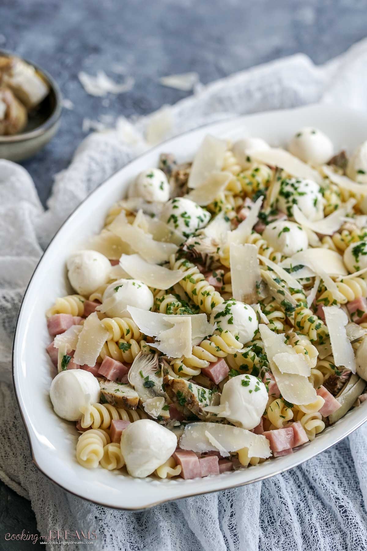 oval platter with marinated artichokes pasta salad.