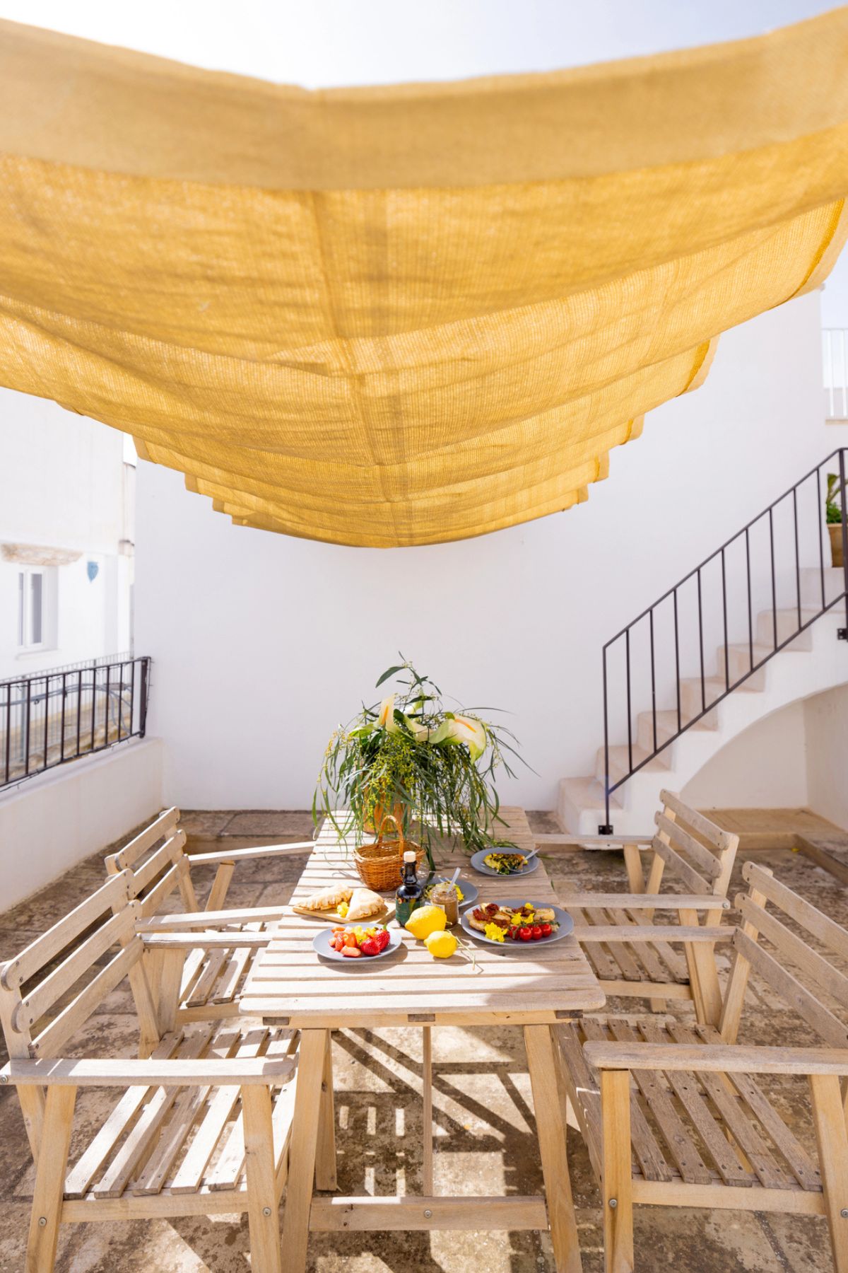 italian table setup on a terrace for a summer lunch.
