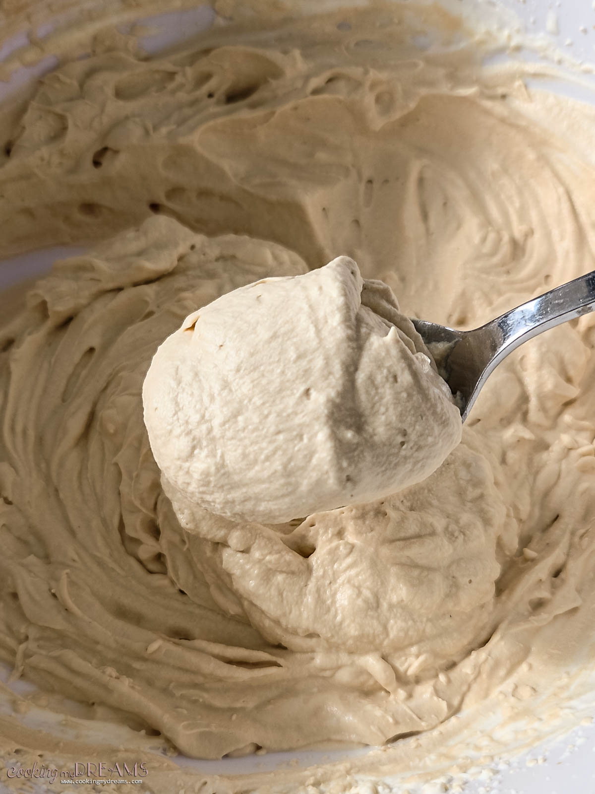 spoon showing the whipped coffee cream from a bowl